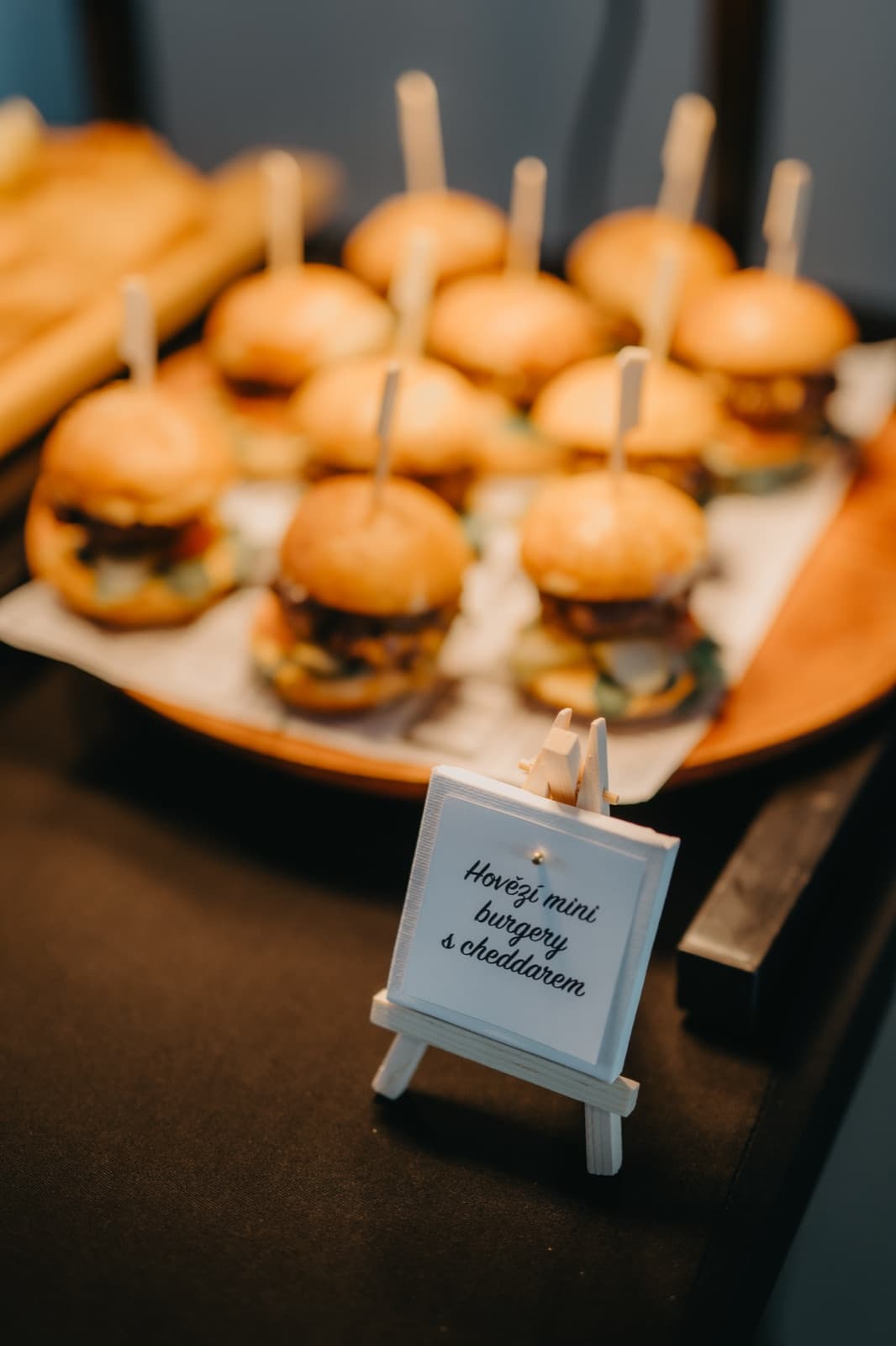 Mini burgery s čedarem na dřevěném podnose