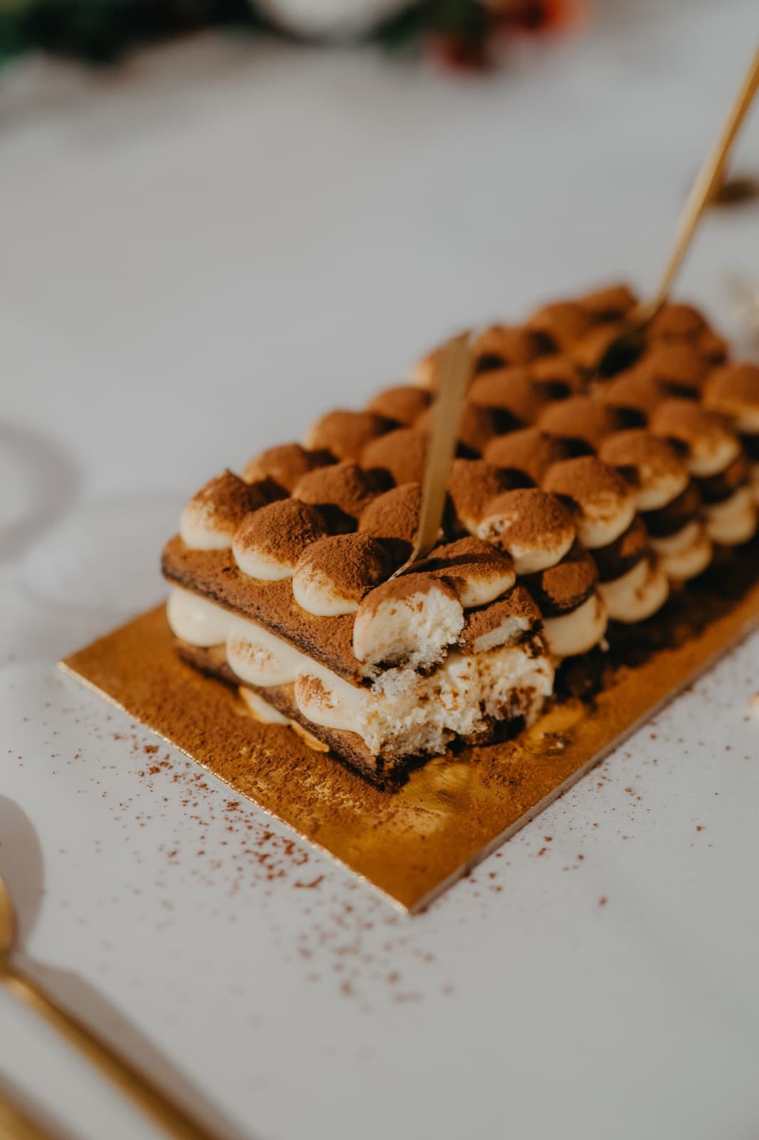 Malé porce tiramisu posypané kakaem na zlatém podnosu