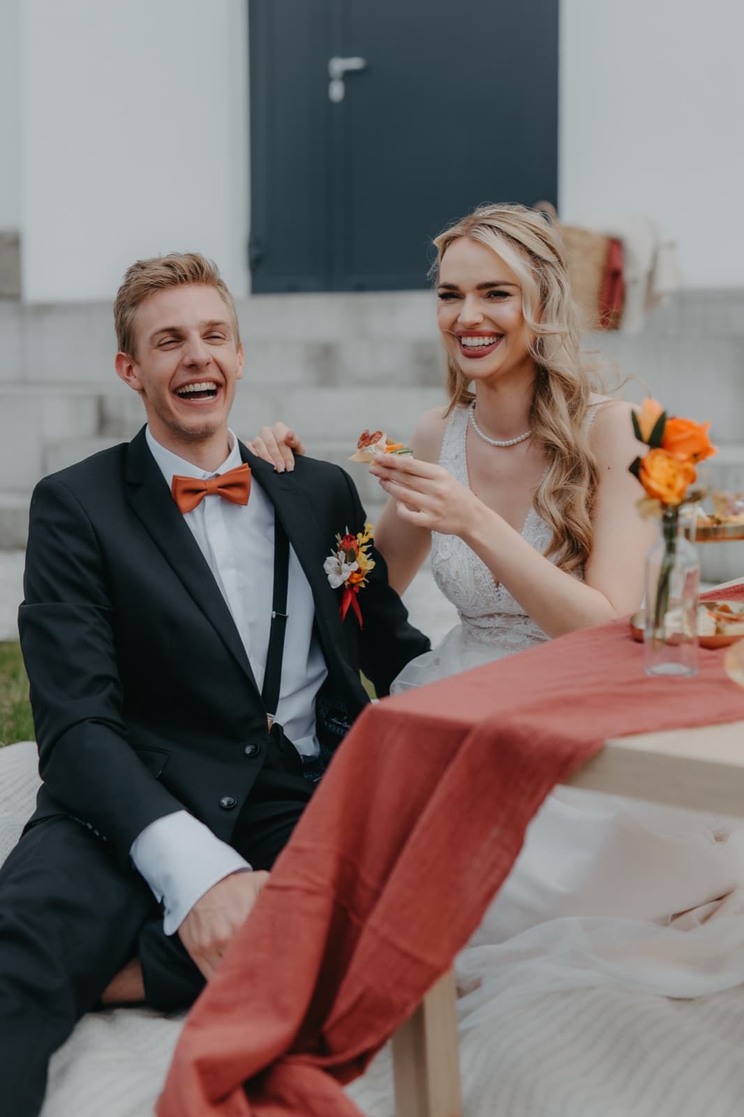 Newlyweds at the wedding table with food and a toast